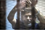   
الرئيس المخلوع محمد مرسي يرفع يديه، بينما القاضي يقرأ نص الحكم